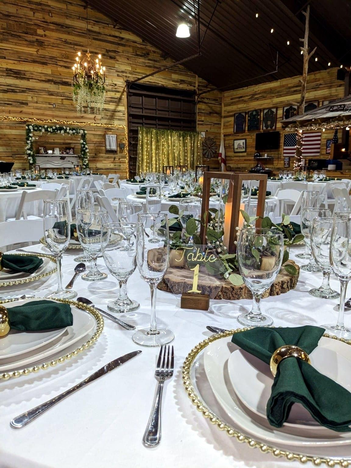 Rustic barn wedding reception with green napkins and lantern centerpieces