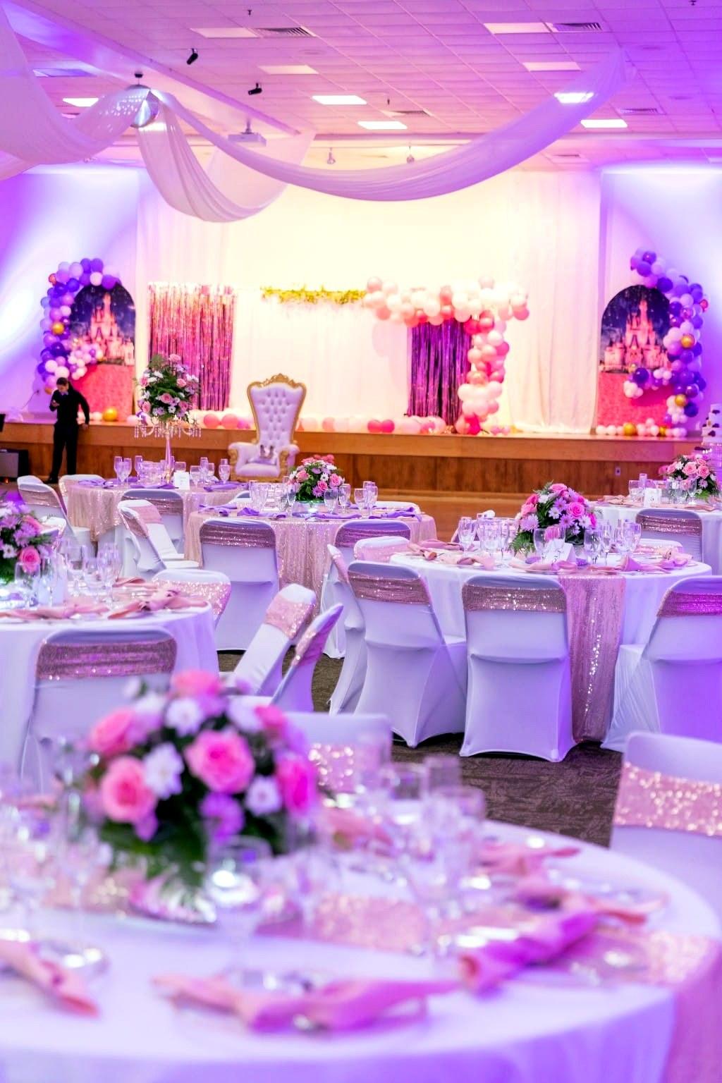 Quinceañera stage with balloon arches and a castle backdrop
