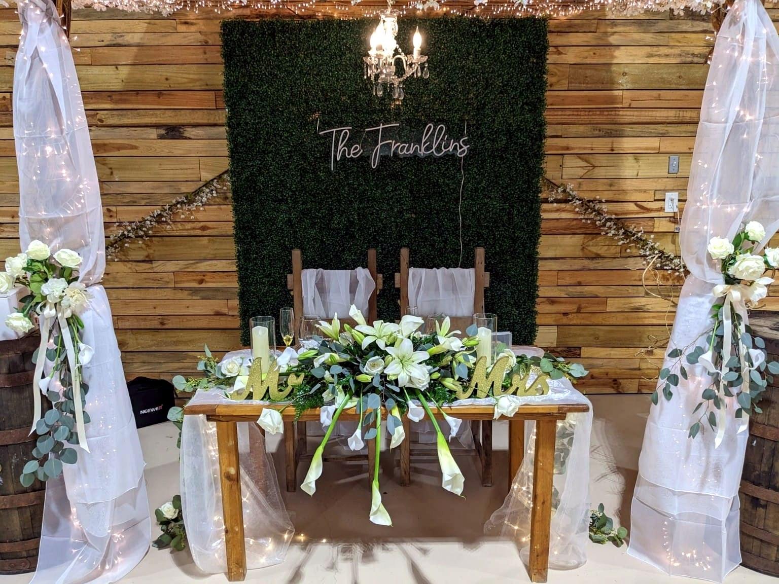 Sweetheart table with a custom sign and white florals